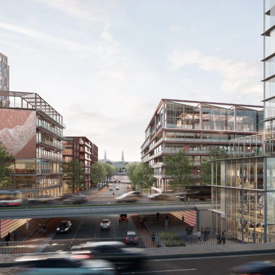 Eine moderne Stadtansicht mit mehreren Glas- und Stahlgebäuden auf beiden Seiten einer Hauptstraße. Im Vordergrund verläuft eine Brücke über eine unterirdische Straße, die von Autos befahren wird.