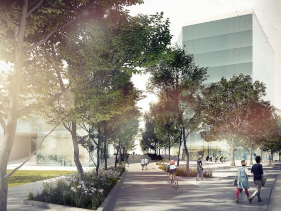 Huckepackbahnhof: Fuß- und Radweg vor zwei Gebäuden, umgeben von Grün.