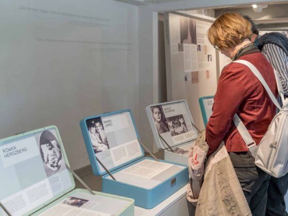 Besucher betrachten Ausstellungen über Einzelpersonen in einer Gedenkstätte.