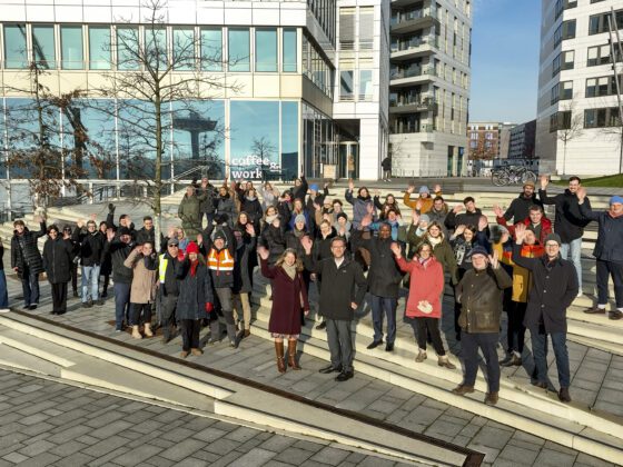 Eine Gruppe von Menschen, die in Richtung Kamera winken.